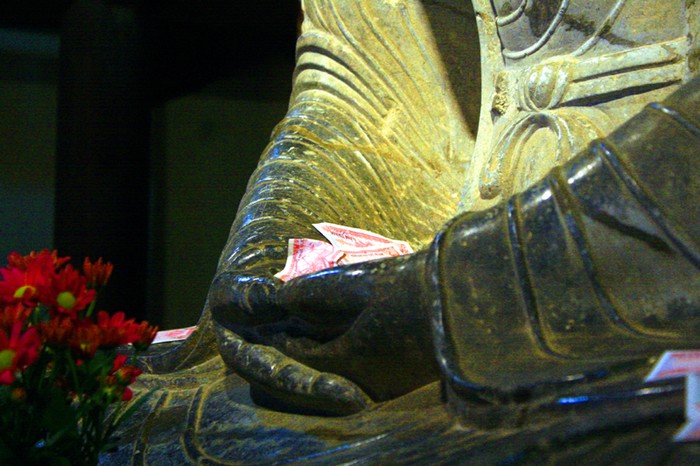 Tiền lẻ nằm trong lòng bàn tay Phật tổ
